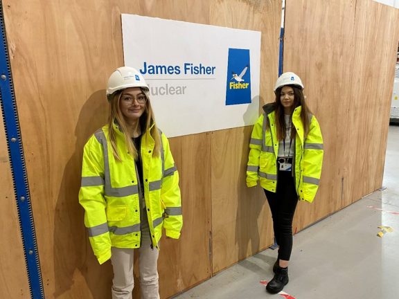 Two women wearing hard hats and hi vis jackets