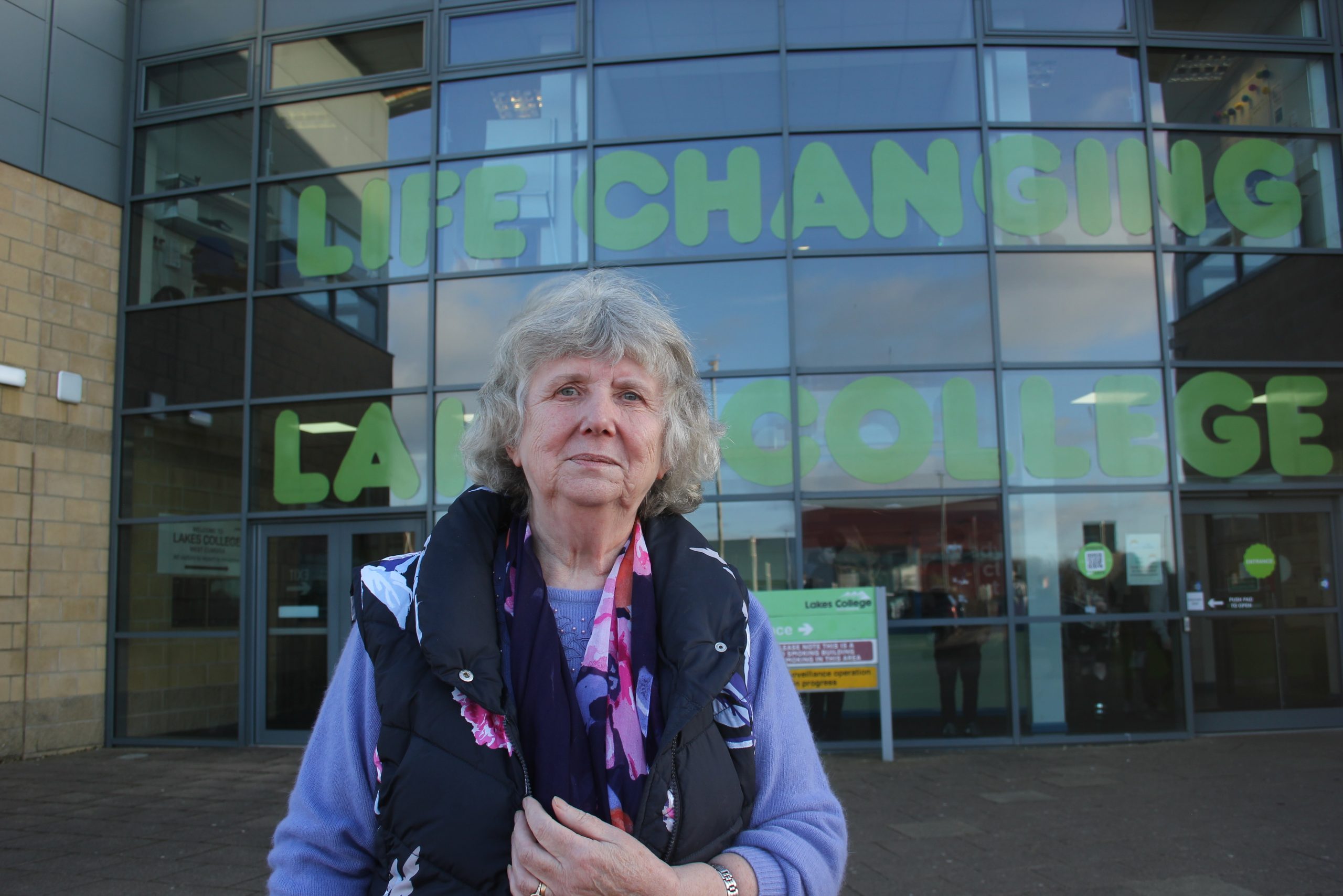 A woman stands in front of a building