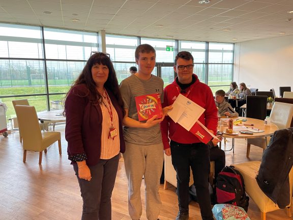 Two boys hold certificates they have been presented with by Eliza Treme-Swailes