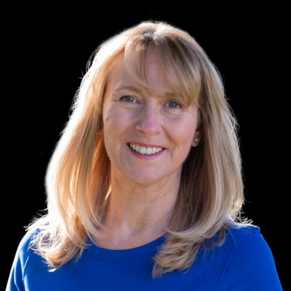 A woman smiles at the camera