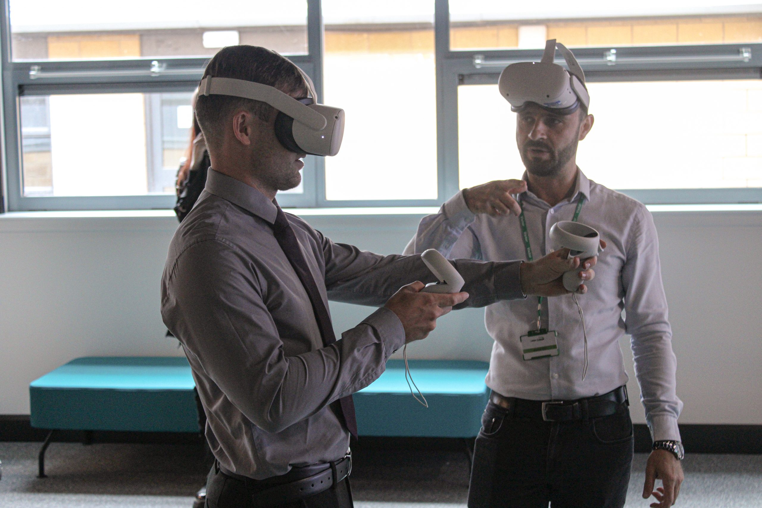 A man wearing a VR headset attempts to work the technology